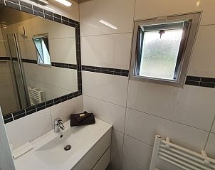 Badkamer met wastafel in Huisje in Haastrecht, vakantiehuis in Zuid-Holland, voorzien van moderne gemakken.