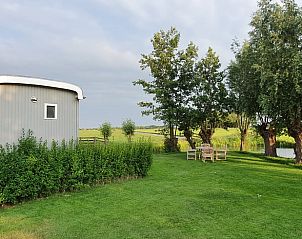 Tuin bij Huisje in Haastrecht, vakantieaccommodatie in Zuid-Holland, met zitgelegenheid en groene natuur.