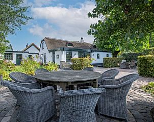 Buitenruimte van Vakantiehuis in Aarlanderveen met grote tafel en stoelen.