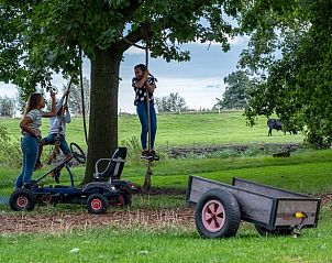 Kinderen spelen in de tuin van Vakantiehuisje in Aarlanderveen, Zuid-Holland.