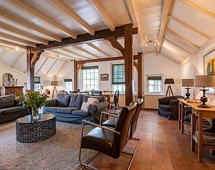 Ruime woonkamer in Huisje in Aarlanderveen, een vakantiehuis in het Groene Hart, Zuid-Holland, met comfortabele zithoek en houten balken.