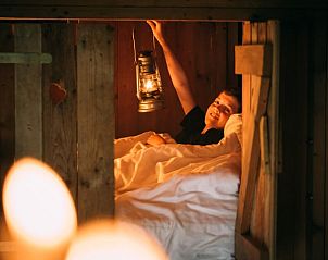 Gezellige slaapkamer in Vakantiehuisje in Aarlanderveen, Groene hart, Zuid-Holland, met warme houten inrichting en sfeervolle verlichting.