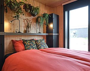 Slaapkamer in Huisje in Boskoop, vakantiehuis in Boskoop, Zuid-Holland, met planten.