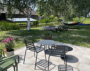 Buitenruimte met zitgelegenheid en groen bij Vakantiehuisje in Nieuwkoop, bed and breakfast in het Groene Hart, Zuid-Holland.