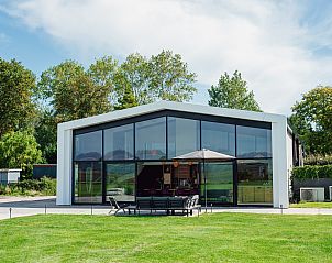 ZH474 vakantiehuis in Noordwijkerhout, Noordzeekust, Zuid-Holland met moderne glazen gevel en ruim terras in groene omgeving.