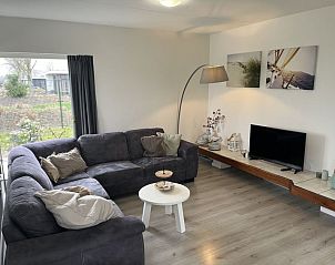Gezellige woonkamer van Vakantiehuis Groepsaccommodatie 12 in Hellevoetsluis met comfortabele zitplaatsen en sfeervolle decoratie.