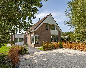 Voorzijde van Vakantiehuis Groepsaccommodatie 12 in Hellevoetsluis, omgeven door weelderige tuinen en natuurlijke schoonheid.
