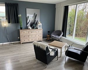 Stijlvolle zitkamer in Vakantiehuis Groepsaccommodatie 12, Hellevoetsluis, met moderne meubels en uitzicht op de tuin.