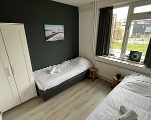 Gezellige slaapkamer in Vakantiehuis Groepsaccommodatie 12, Hellevoetsluis, met comfortabele bedden en rustgevende kleuren.