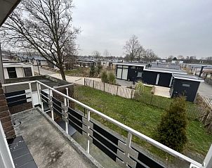 Buitenaanzicht van lodges nabij Vakantiehuis Groepsaccommodatie 12, Hellevoetsluis, omgeven door groene natuur.