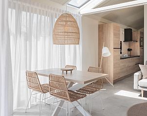 Lichte en moderne eetruimte in vakantiehuis Sky 4 in Zwartewaal, Voorne Putten, Zuid-Holland met houten meubels en veel natuurlijk licht.