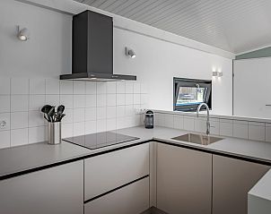 Moderne keuken in vakantiehuis Meadow 6, Zwartewaal, Voorne Putten. Strakke inrichting met kookplaat en uitzicht op de omgeving.
