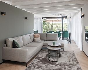 Gezellige woonkamer van vakantiehuis Sunset 6 in Zwartewaal, Voorne Putten. Modern interieur met uitzicht op de tuin in Zuid-Holland.