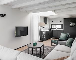 Moderne woonkamer in vakantiehuis Sunset 6, Zwartewaal, Voorne Putten, Zuid-Holland met stijlvolle inrichting en open keuken.