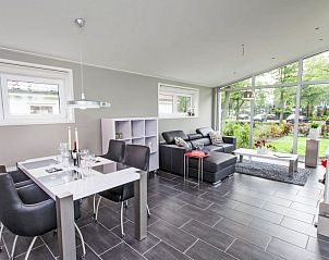 Lichte woonkamer van Vakantiehuis Pavilion 6 in Dordrecht, Zuid-Holland met uitzicht op de tuin.