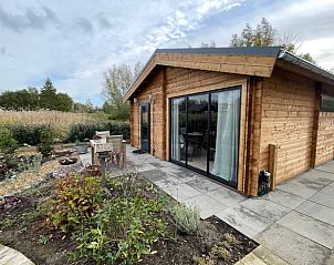 Huisje in Poortugaal, een charmant vakantiehuis in Rotterdam eo, Zuid-Holland, met een uitnodigend terras en groene omgeving.