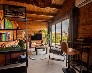 Gezellige woonkamer in Huisje in Poortugaal, een vakantiehuis in Rotterdam eo, Zuid-Holland, met houten interieur en uitzicht op de tuin.