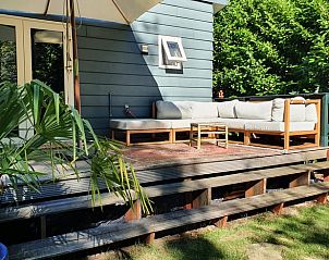 Gezellige zithoek op het terras van vakantiehuisje in Groesbeek, omringd door natuur in het Rijk van Nijmegen, Gelderland.