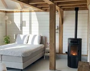 Moderne slaapkamer met houtkachel in Huisje in Alverna, vakantiehuis in Rijk van Nijmegen, Gelderland.