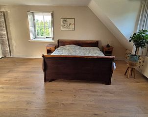 Ruime slaapkamer met houten vloer in Huisje in Overasselt, een gezellig vakantiehuis in het Rijk van Nijmegen, Gelderland.