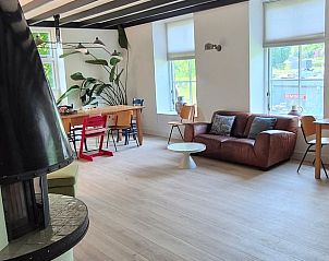 Lichte en ruime leefruimte in Vakantiehuisje in Overasselt, Gelderland, met grote ramen en veel natuurlijk licht.