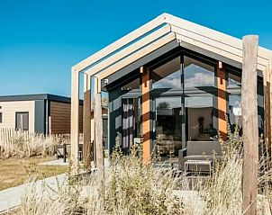 Voorzijde van Chalet De Zeester nr. 718, een vakantiehuis in Strandpark de Zeeuwse Kust, Renesse, omgeven door natuur.